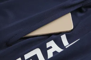 Nahaufnahme der Tasche eines dunkelblauen Basketballtrikots mit einem Smartphone darin