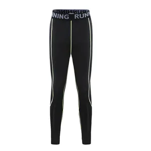 Professional detail view of black children's compression leggings with green side stripes