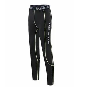Side view of black children's compression leggings with green contrast stitching