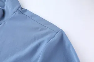 Detalle que muestra la costura del hombro y textura de la tela de chaqueta deportiva