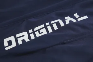 Detailaufnahme eines dunkelblauen Basketballtrikots mit weißem ORIGINAL-Aufdruck.