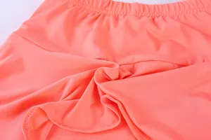 Close-up of coral quick-dry fabric and elastic waistband on a sports tennis skirt