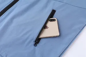 Primer plano del bolsillo funcional con cremallera en una chaqueta deportiva azul para hombre.