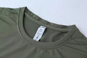 Close-up detail of a dark green athletic sports T-shirt neckline with a size M wash label