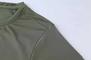 Close-up detail of green athletic t-shirt showing fabric texture and shoulder stitching