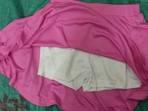 Detail view of pink quick-dry tennis skort for girls showing white inner safety shorts