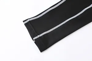 Dettaglio ravvicinato di legging a compressione sportivi con cuciture piatte bianche ai bordi