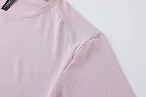 Détail du t-shirt de sport rose pour homme montrant la texture respirante.