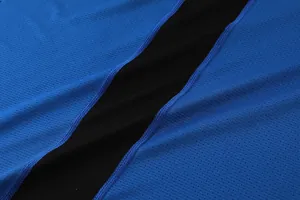 Macro close-up of breathable blue and black mesh fabric with reinforced sports stitching.