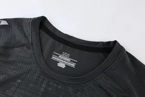 Detail shot of men's dark grey athletic compression t-shirt neckline and fabric texture