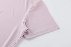 Vue détaillée de la texture du tissu et de la manche du t-shirt de sport rose.