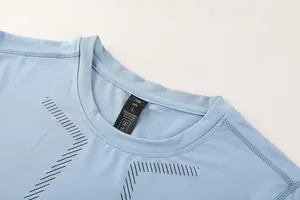 Detailed view of the neckline and size label on a light blue men's athletic compression shirt