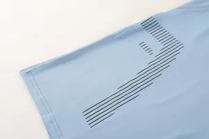 Close-up detail of light blue men's athletic shirt with black graphic print lines