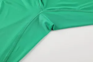 Detailed close-up of high-quality flatlock stitching on green compression sports shirt