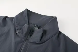 Gros plan du col montant et du zip sur une veste de sport grise pour hommes