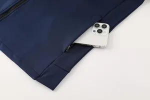 Detailed macro shot of a side pocket on a navy sports jacket holding a smartphone