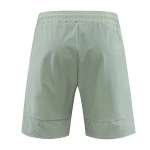 Back view of men's quick-dry athletic shorts in sage green with mesh hem detail