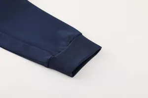 Detailed macro view of the navy blue ribbed cuff on a men's athletic sports jacket