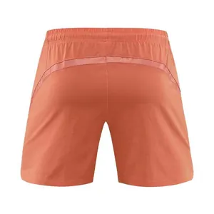 Rear view of men's orange quick-dry athletic shorts featuring a mesh ventilation strip