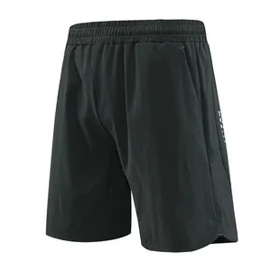 Close-up view of men's quick-dry black sports shorts featuring side mesh panels and pockets