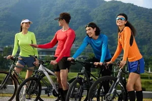 Lifestyle shot of men and women wearing colorful long-sleeved sports compression shirts for cycling