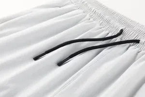 Gros plan détaillé de la taille élastique et des cordons noirs sur un pantalon de sport blanc