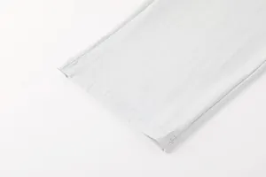 Gros plan détaillé montrant la couture de l'ourlet de ce pantalon de sport gris clair.
