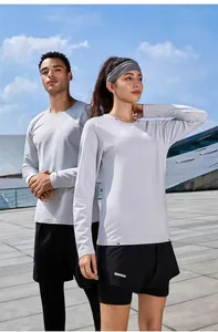 Outdoor athletic couple wearing gray long-sleeve quick-dry running shirts in stadium setting
