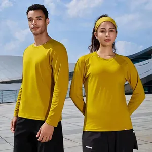 Couple in matching mustard yellow long-sleeved quick-dry sports T-shirts outdoors.