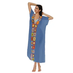 Primer plano del vibrante patchwork floral de ganchillo en un vestido de playa azul mujer