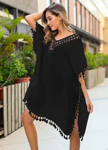 Detailed view of the elegant black crochet neckline and tassel hem on beach cover-up tunic.