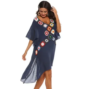 Detail van marineblauwe gehaakte strandcover-up met diepe V-hals en zijdelingse spleten