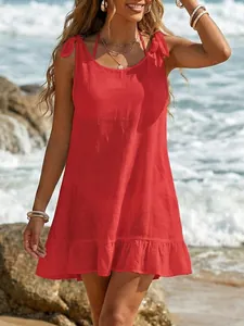 Red sleeveless beach cover-up with ruffled hem and adjustable bow tie straps on beach