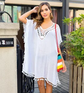Full view of white hand-crocheted beach cover-up with tassel hem on a fashion model