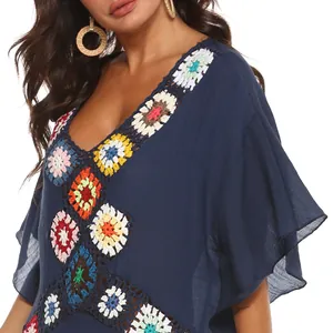 Detail van blauwe strand cover-up met kleurrijke handgemaakte haakwerk patchwork