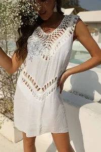 Close-up detail of the hand-crocheted V-neck and fringe on a white beach dress