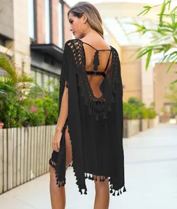 Back view of a black crochet beach cover-up with tassels and an open back design.