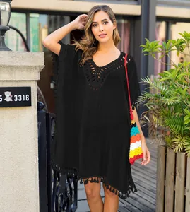 Detail view of black crochet tassel beach cover-up shown on a fashion model outdoors