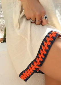 Close-up detail of the hand-crocheted color-block hollow-out hem on beach cover-up