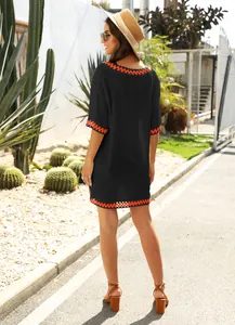 Back view of loose black beach cover-up with vibrant orange crochet trim details