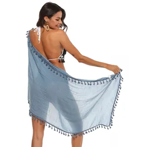 Elegante pareo da spiaggia blu polvere con nappe decorative visto dal retro sulla modella