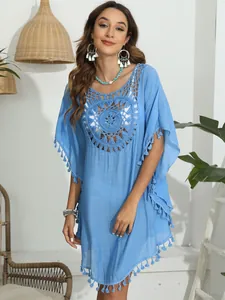 Detailansicht eines blauen Häkel-Bikini-Cover-Ups mit Quasten und floralem Ausschnitt