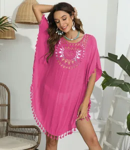 Detailansicht des pinken Strand-Ponchos mit Häkelhals und Quastenverzierung.