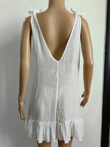 Detailed back view of white beach cover-up with adjustable bow straps and ruffle hem