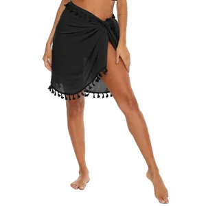 Dettaglio del pareo da spiaggia nero a portafoglio con elegante orlo a nappine.