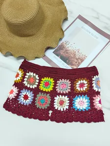 Vista detallada de pantalones cortos de ganchillo burdeos hechos a mano con motivos coloridos.