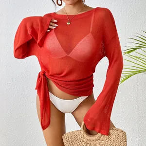 Close-up of vibrant red sheer mesh beach cover-up featuring elegant tie-side hem details