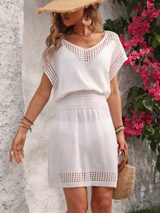 Detalle de vestido de playa de ganchillo calado blanco con cintura elástica y cuello en V