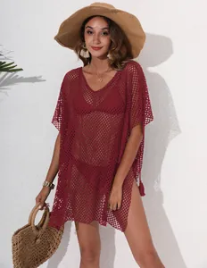 Detail shot of a burgundy mesh beach cover-up with tassel decoration.