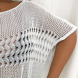 Close-up detail of a white crochet knit beach cover-up with hollow out design.